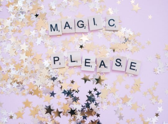 Glitter, metallic cofetti, surrounding the words "Magic Please"