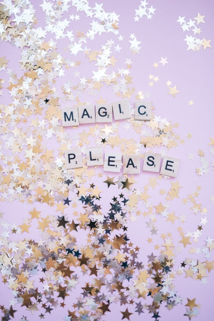 Glitter, metallic cofetti, surrounding the words "Magic Please"